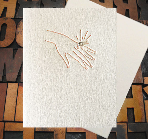 Letterpress Card with an image of a woman's hand bearing an engagement ring that features a real rhinestone
